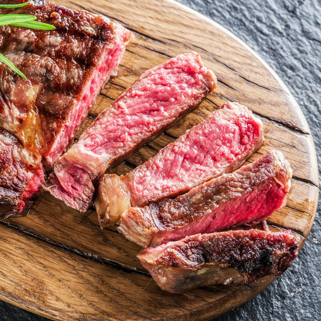 Medium Ribeye steak with spices on the wooden tray.