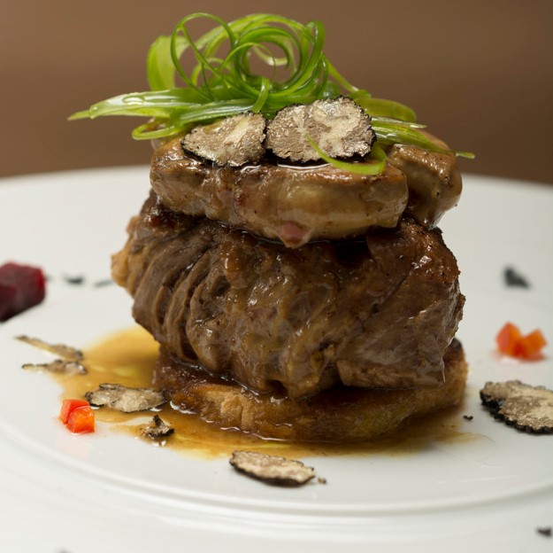 Sliced truffles topped on a grilled steak, beef and pork, with